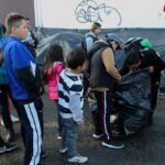 Niños migrantes reciben regalos de Navidad enviados por aficionados del equipo de fútbol FC Juárez, cerca del puente internacional Paso del Norte-Santa Fe, en Ciudad Juárez, México, el 25 de diciembre 2019