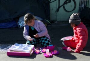 Niños migrantes con juguetes que recibieron como regalo de Navidad y que fueron enviados por aficionados del equipo de fútbol FC Juárez, cerca del puente internacional Paso del Norte-Santa Fe, en Ciudad Juárez, México, el 25 de diciembre de 2019