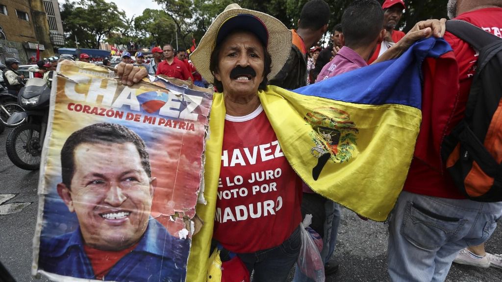 Un hombre sostiene una fotografía de Hugo Chávez