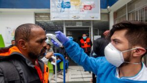 Médico ecuatoriano toma la temperatura a un hombre en la frontera con Colombia