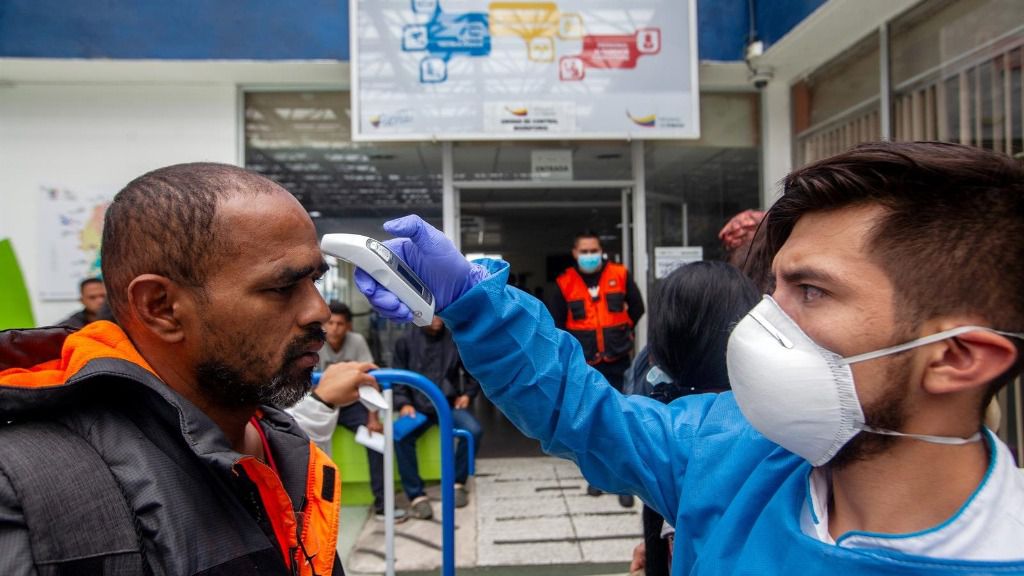 Médico ecuatoriano toma la temperatura a un hombre en la frontera con Colombia
