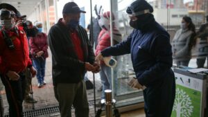 Una personas es rociada con gel desinfectante antes de ingresar en eun centro comercial de Bogotá, Colombia