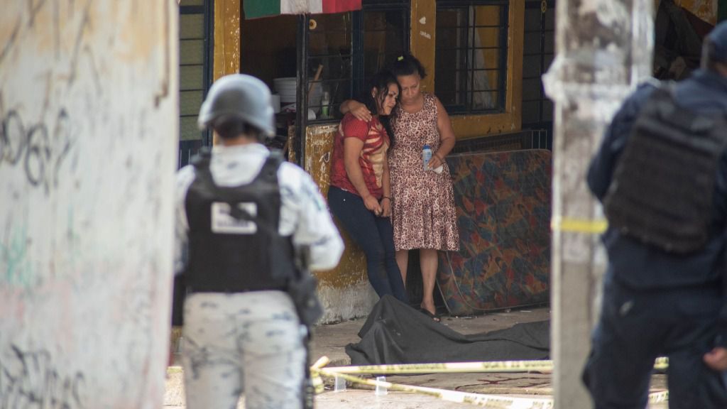 Dos mujeres junto al cadáver de un hombre abatido en Veracruz, México
