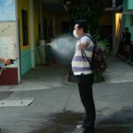 Un migrante hondureño es desinfectado tras su llegada Guatemala en plena pandemia