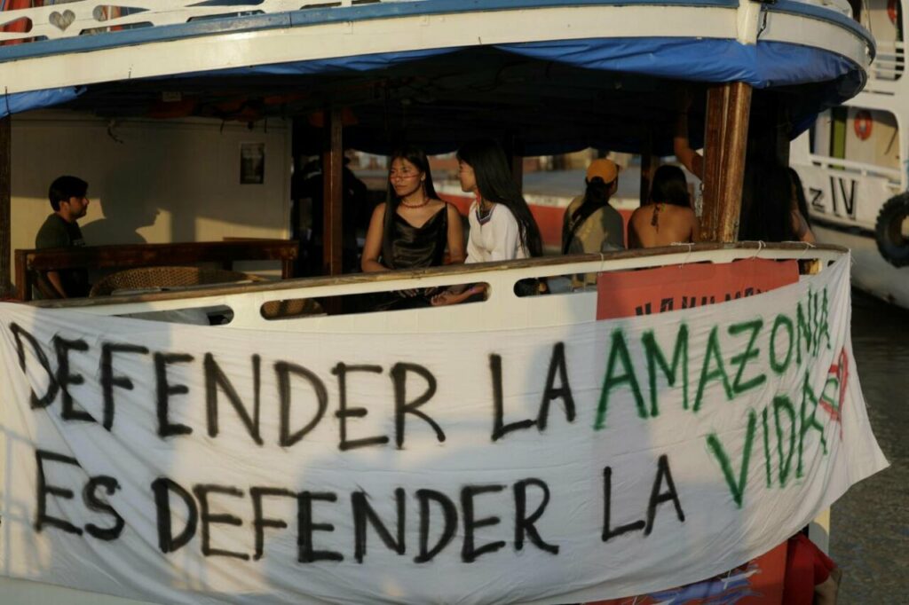 Indígenas descansan en la flotilla Yaku Mama Amazon, proveniente de Ecuador, que llegó el 9 de noviembre a Belém (Brasil) después de navegar 3 000 km por el río Amazonas. / EFE | Antonio Lacerda