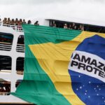 Protesta indígena en Belém con bandera de la Amazonía protegida