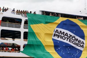 Protesta indígena en Belém con bandera de la Amazonía protegida