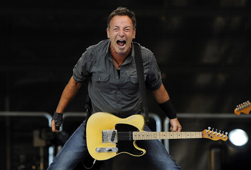 Bruce Springsteen actuando con guitarra en un concierto enérgico
