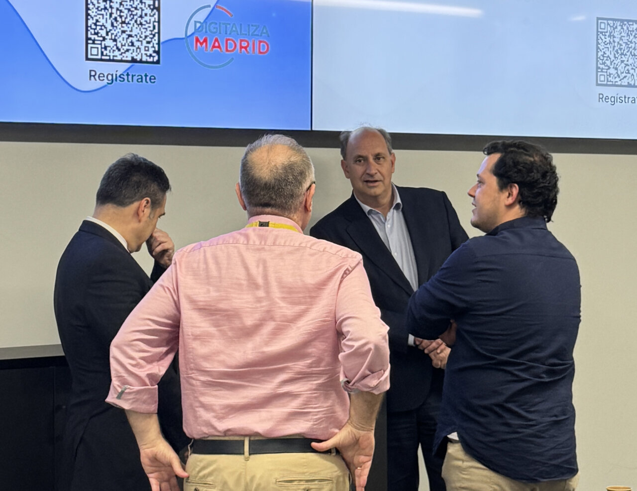 Cuatro personas conversando en el hackathon de Madrid sobre soluciones WhatsApp.