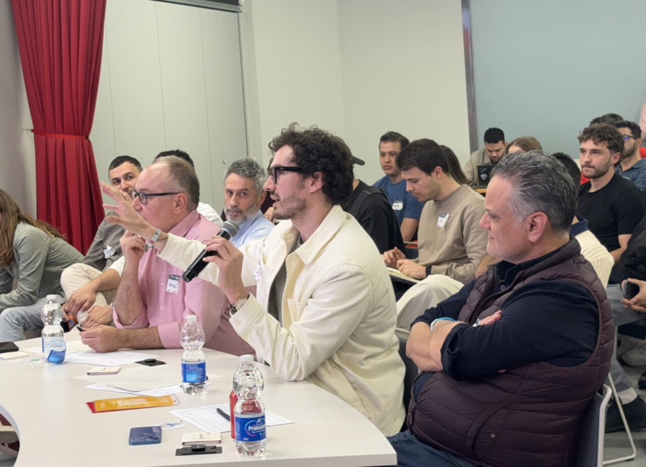Participantes del jurado en el hackathon de Madrid discutiendo soluciones tecnológicas.