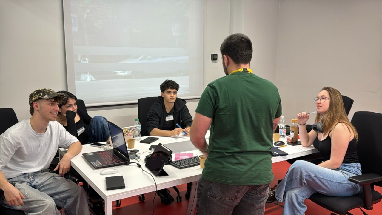 Participantes colaborando en un hackathon en Madrid sobre WhatsApp.