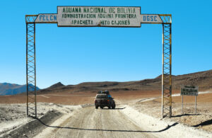 Señal de aduana en la frontera entre Bolivia y Chile con un vehículo