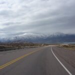 Carretera en Argentina con montañas nevadas al fondo