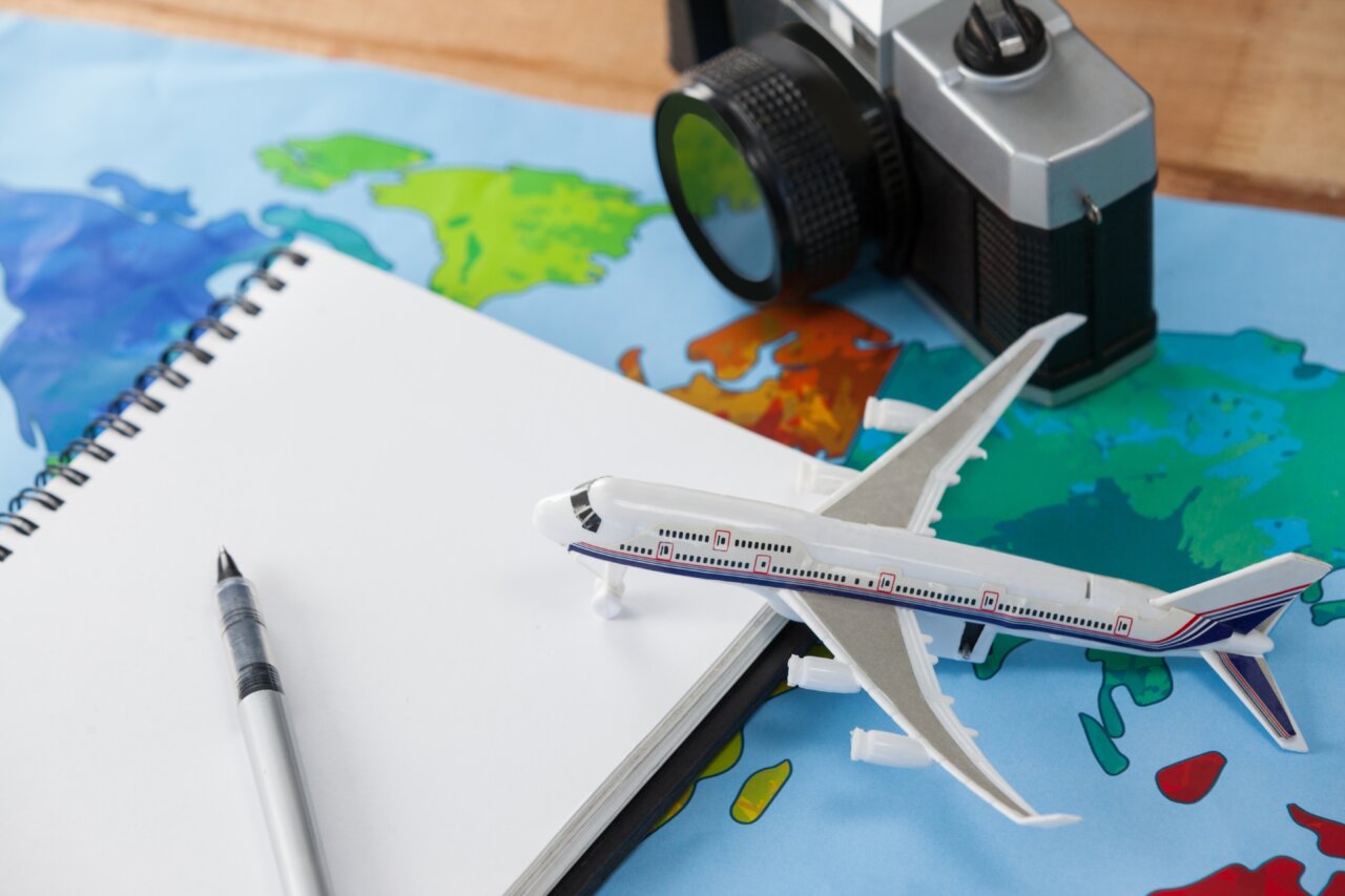 Modelo de avión sobre un mapa y una libreta de notas